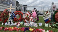 The small memorial on the event site: Photos of those killed are lined up on the fence