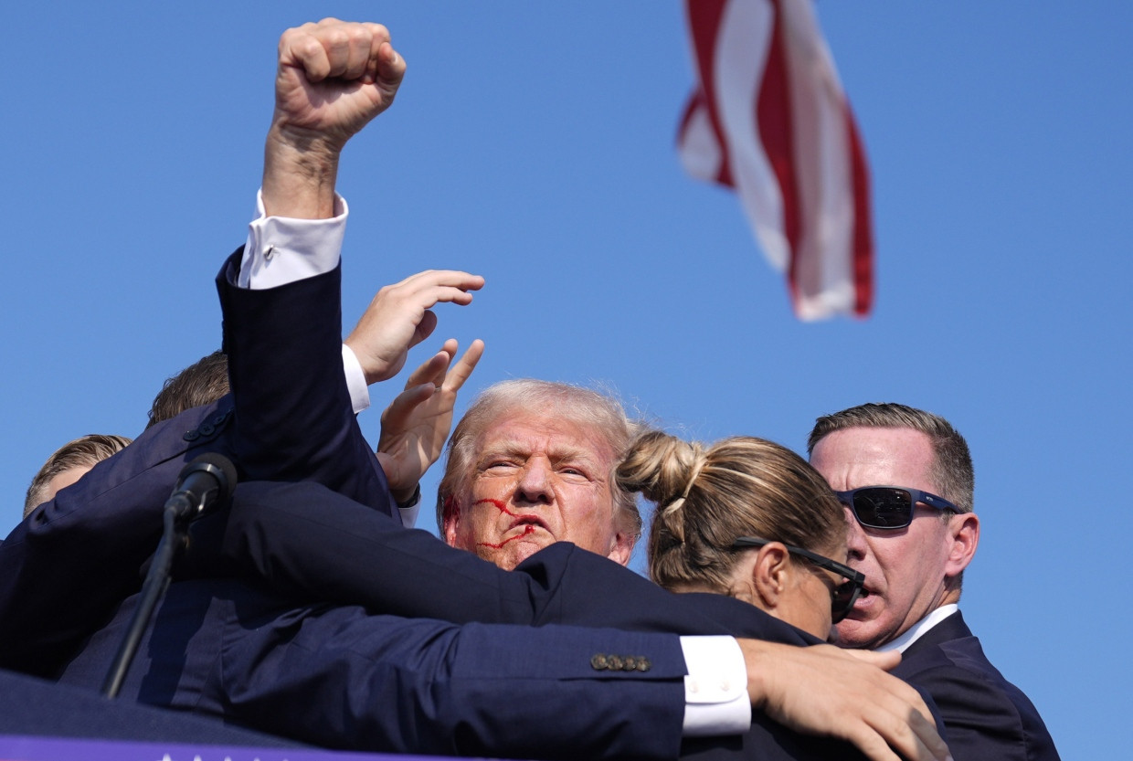 Combative: Trump raises his fist in the air after the assassination attempt.