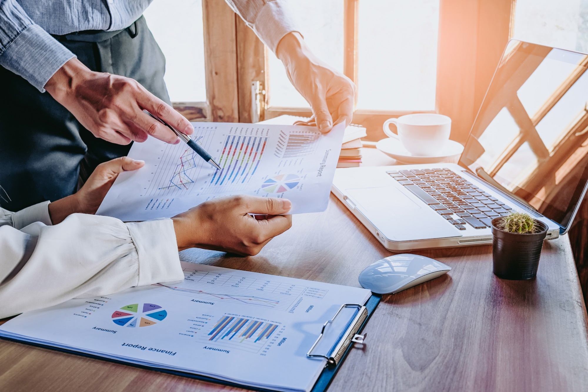 Business team analyzing income charts and graphs with modern laptop computer