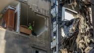 The building hit by an Israeli drone in Beirut is inspected by civil defense personnel.