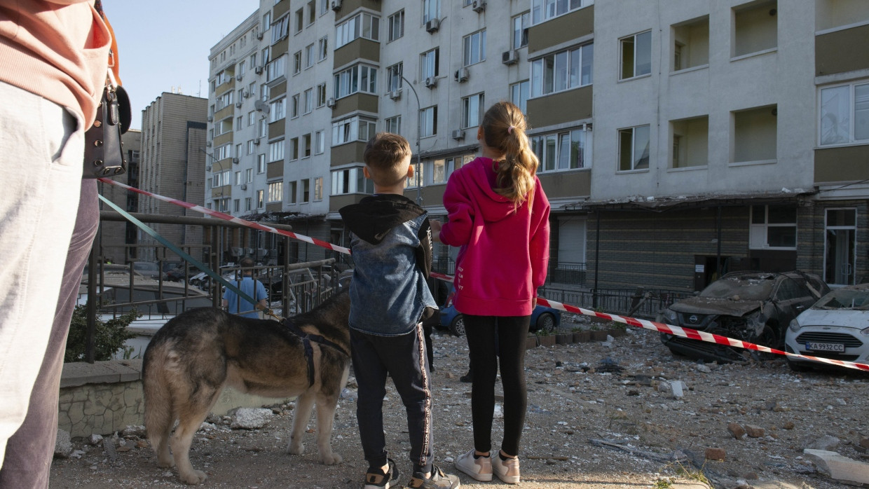 Children look at heavily damaged buildings in May 2023, which were damaged in the third Russian airstrike on the Ukrainian capital in the last 24 hours.