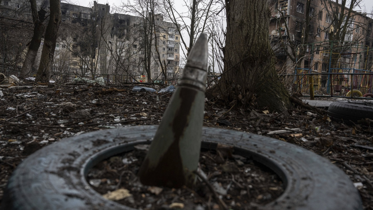 Part of a rocket protrudes from the ground in front of a residential building in Wuhledar that was heavily bombed by Russian forces