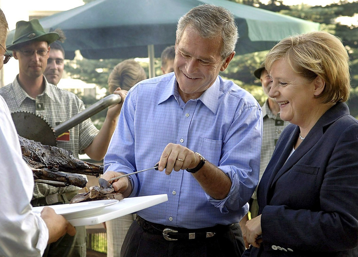 A piece of meat from the American president: George W. Bush and Angela Merkel at a barbecue evening in Trinwillershagen in July 2006