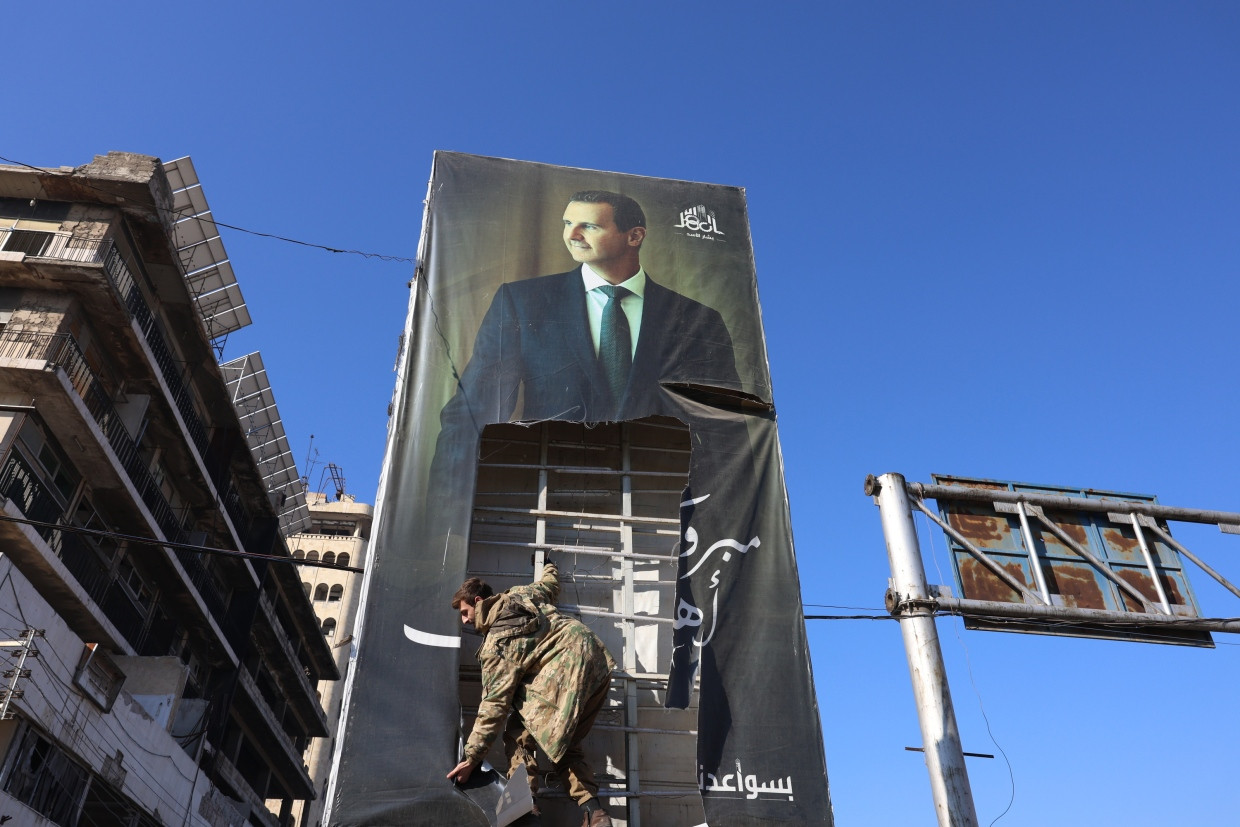 In Aleppo: Ein Kämpfer reißt ein Plakat von al-Assad von einer Wand.