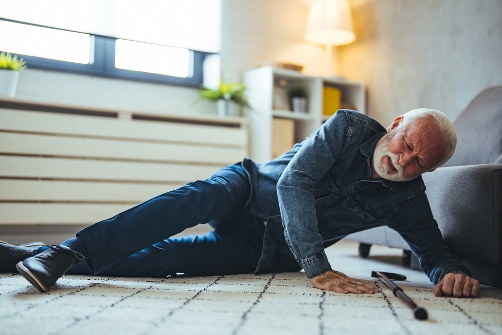 Disabled Senior Man Lying On Carpet