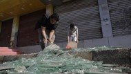 Yemenis clean debris in front of their shops after a US air attack.