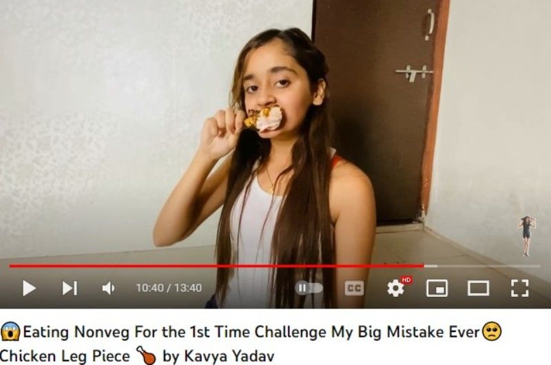 An image of Kavya Yadav eating chicken; snip from Kavya Yadav's YouTube vlog titled Eating Nonveg For the 1st Time Challenge My Big Mistake Ever