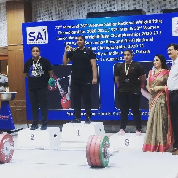 Purnima Pandey standing on the podium after gold in the 36th Women Senior National Weightlifting Championships