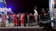 Migrants disembark the sea rescue ship 