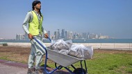 Hard work: A Pakistani migrant worker in front of the skyline of the Qatari capital Doha