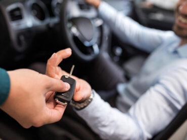 Driver receiving car keys at car rental agency