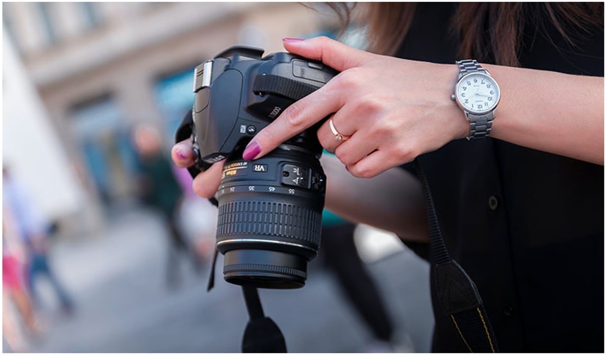 A woman holding an expensive camera
