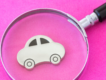 Magnifier over car with pink background