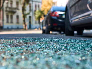 Shards of glass on the street following a vehicle accident.