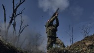 a Ukrainian soldier fires a grenade launcher on the front line in Bakhmut.