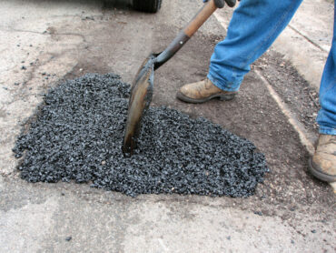 Pothole being filled with asphalt on residential street