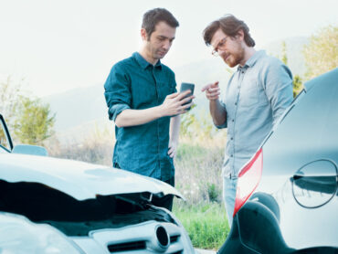 Two men trying to find an agreement after a car accident