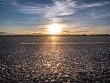 Asphalt road in sunset close up